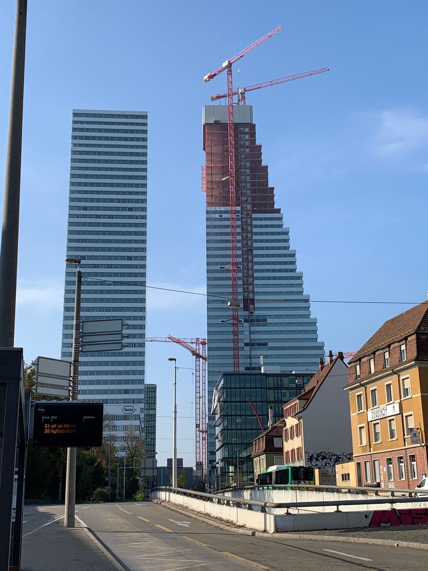 Die Roche Türme in Basel vom Strassenniveau aus gesehen, Bau 2 noch im Rohbau mit Kran