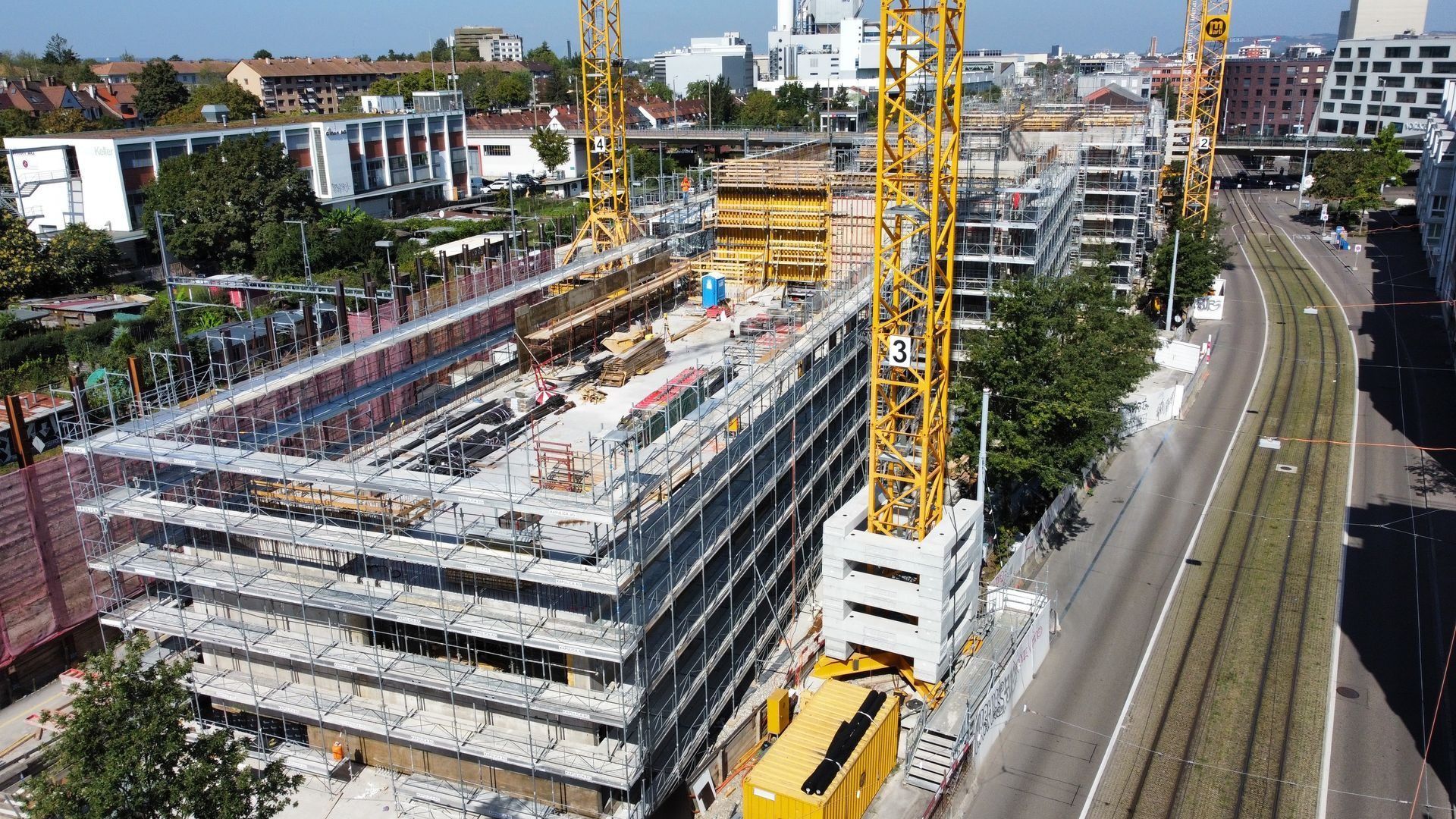 Rohbau mit Gerüst und Kran an einer Strasse