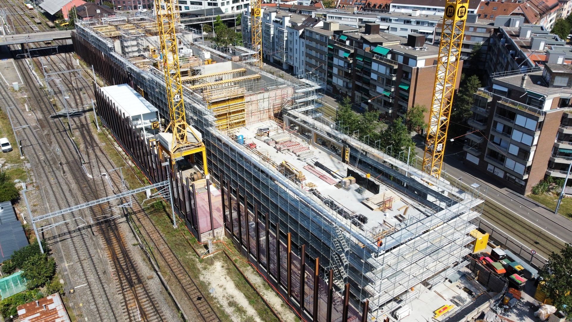 Baustelle neben Bahngleisen von oben
