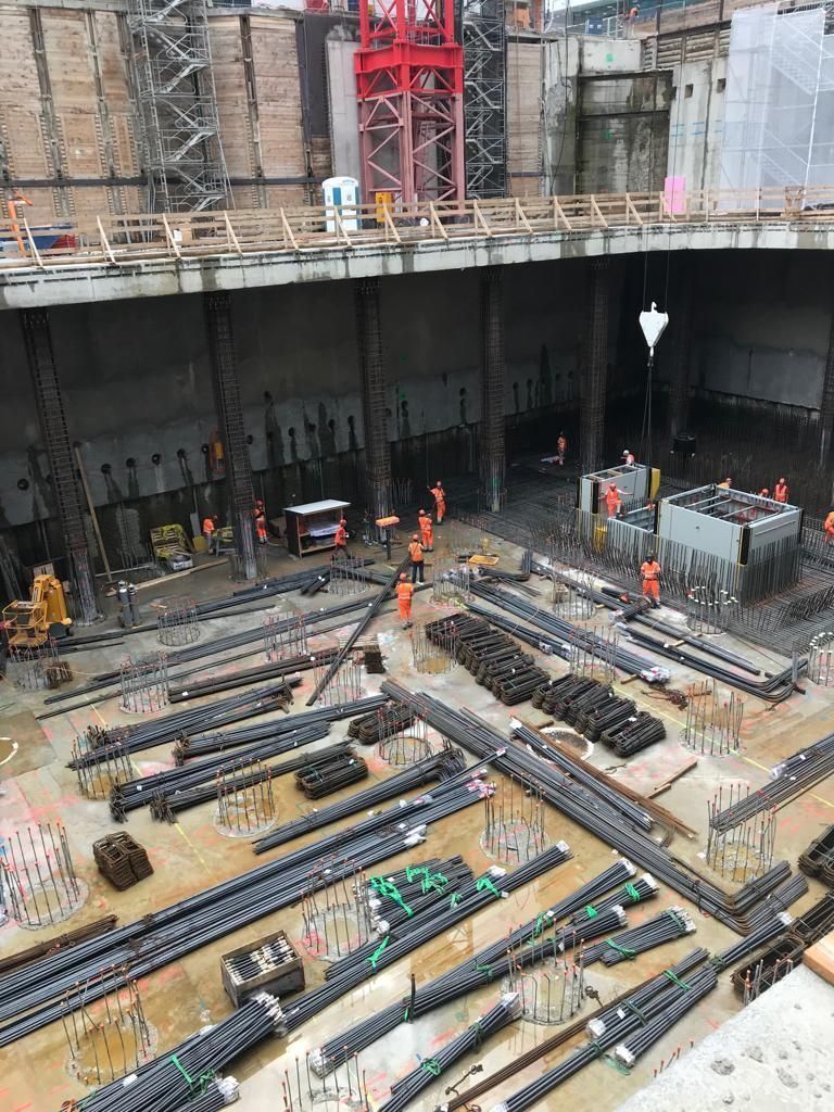 Baugrube mit Bewehrungsstäben und Eisenlegern bei der Arbeit